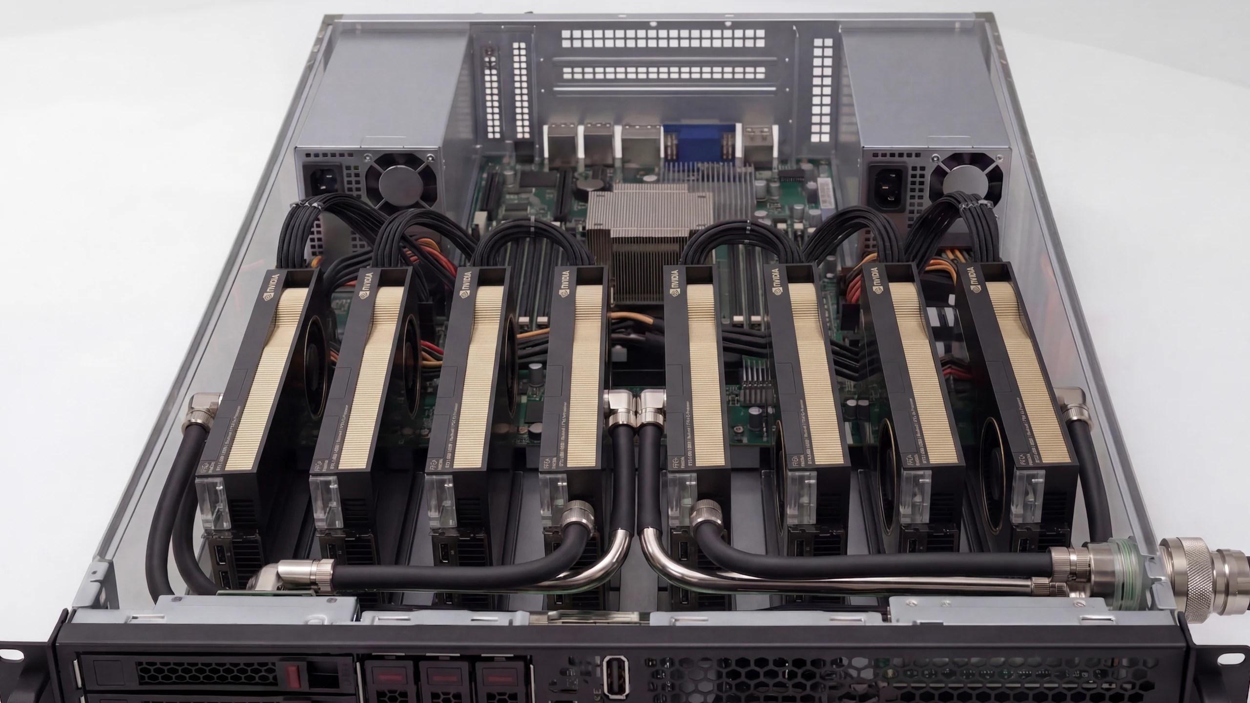 Top-down view of an open eight-GPU accelerator node: eight cards in a row with liquid-cooling loops, dual power supplies, and the mainboard in a rack chassis.